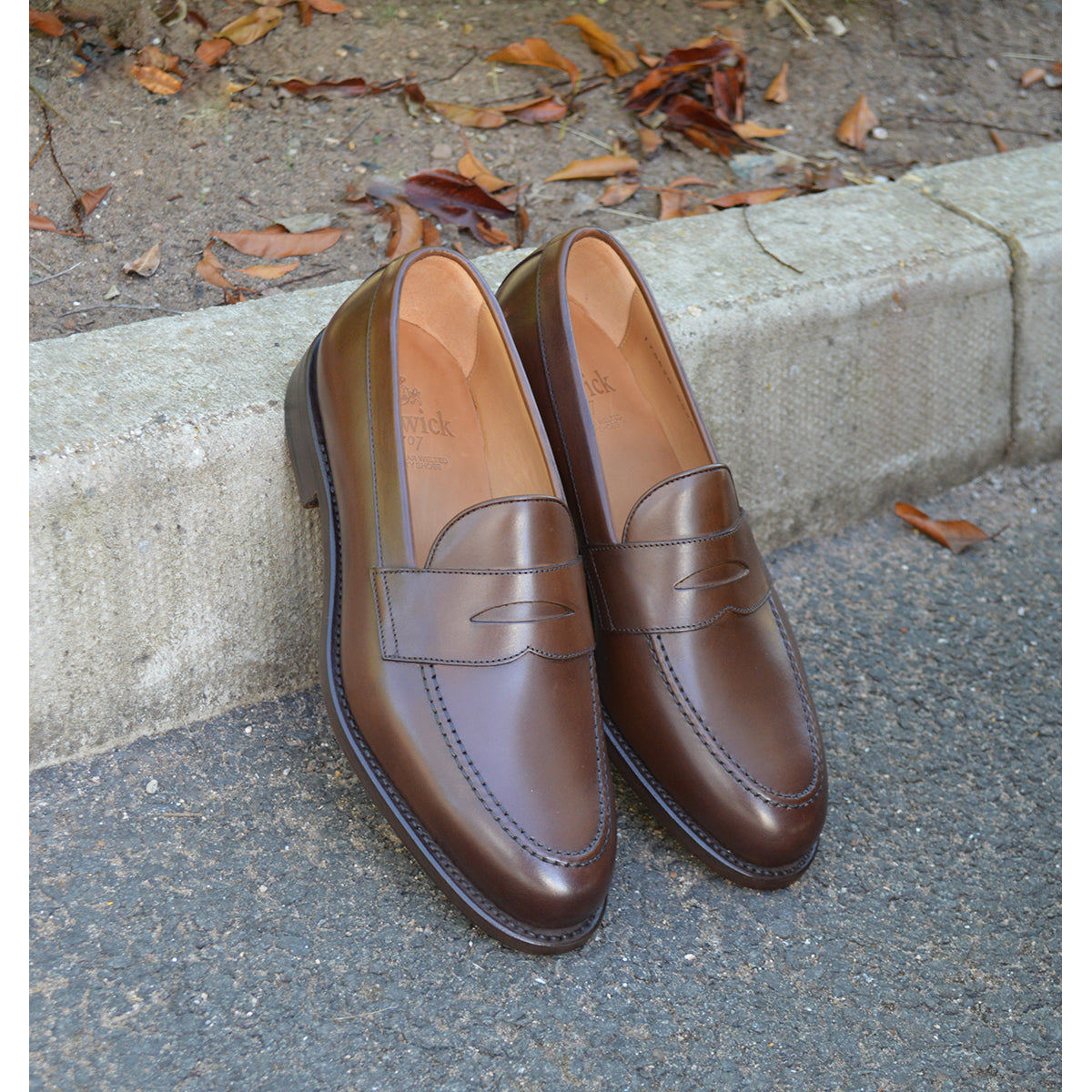 Berwick 1707 Brown leather loafer shoe on a concrete kerb background
