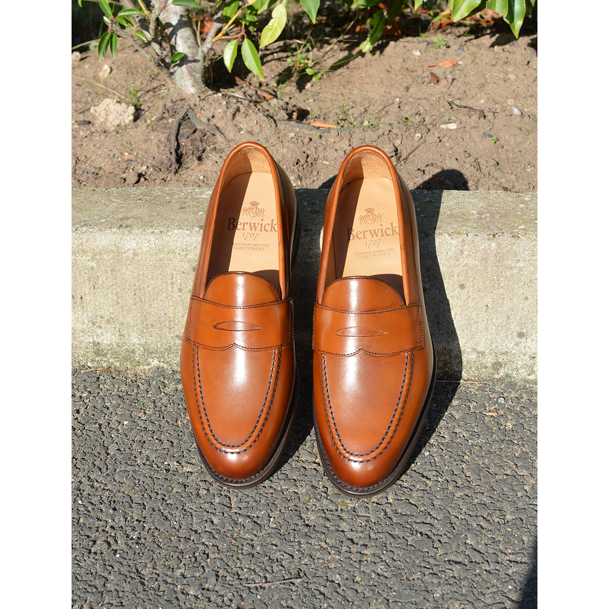 Berwick 1707 Brown tan leather loafer shoe on a polished concrete curb with Dainite Soles