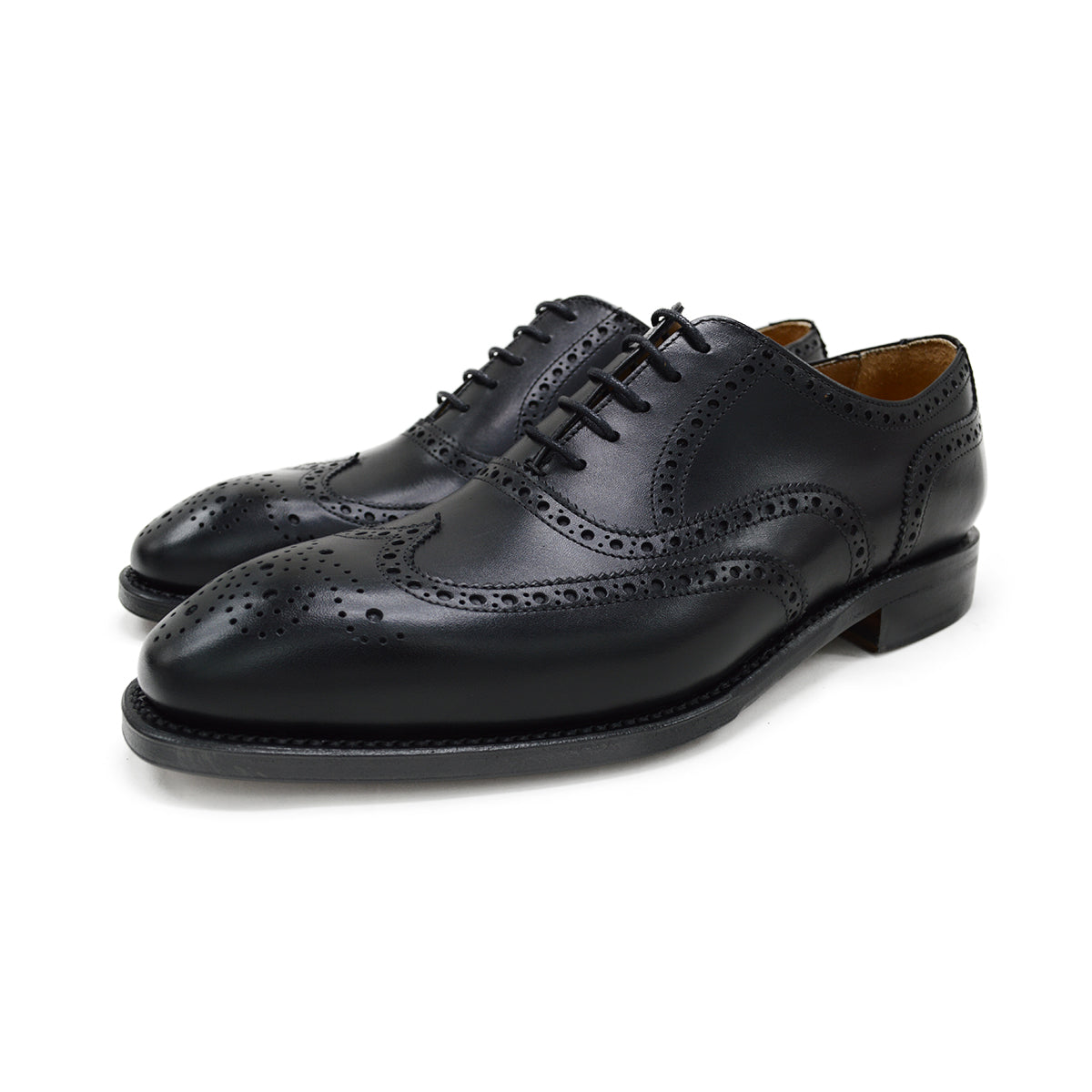 A Berwick 1707 black Oxford brogue shoe with brogue detailing and a lace-up closure. The shoe is made of smooth leather and appears to be sturdy and durable.