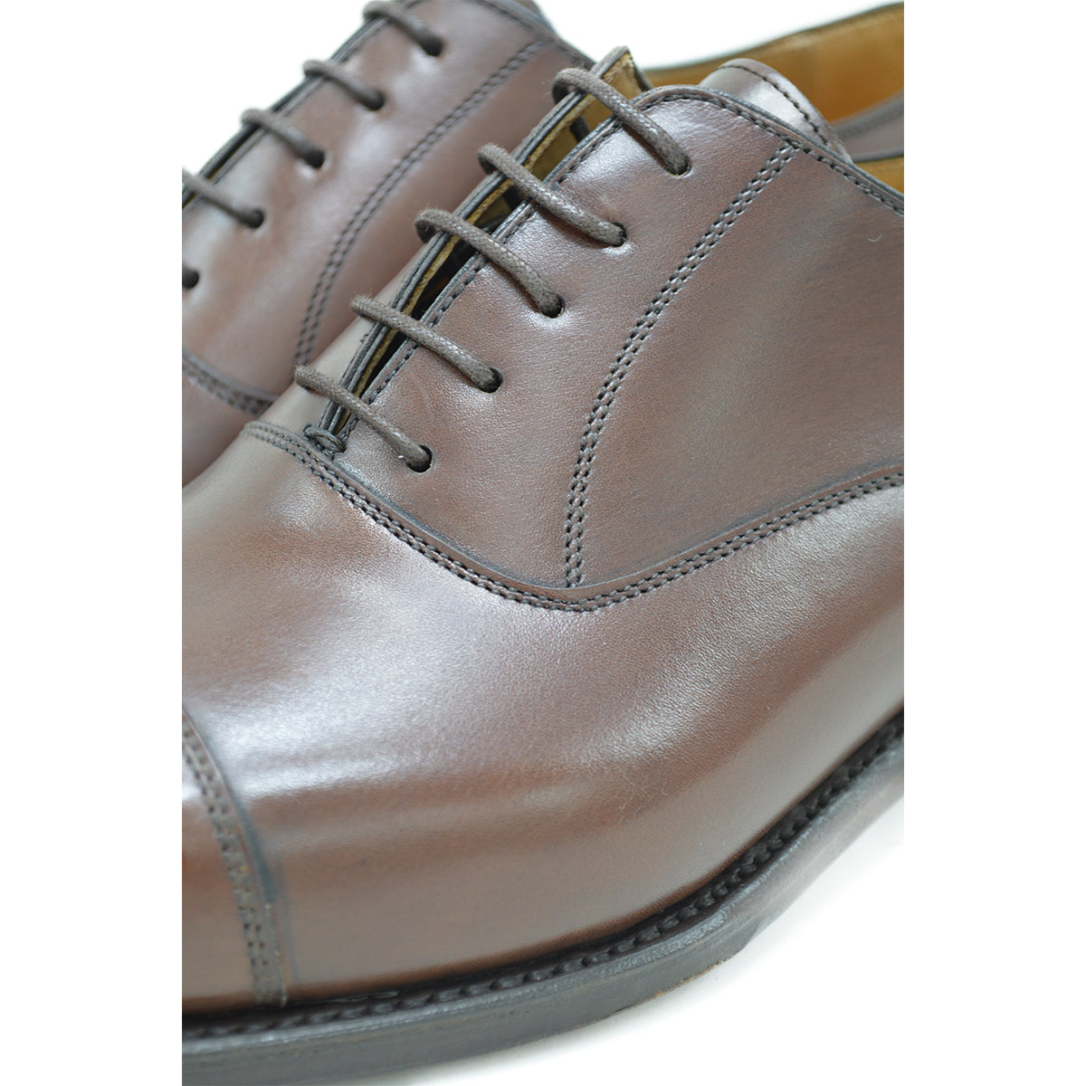 A Berwick 1707 dark brown, chisel toe Oxford shoe with a lace-up closure and a single leather sole.