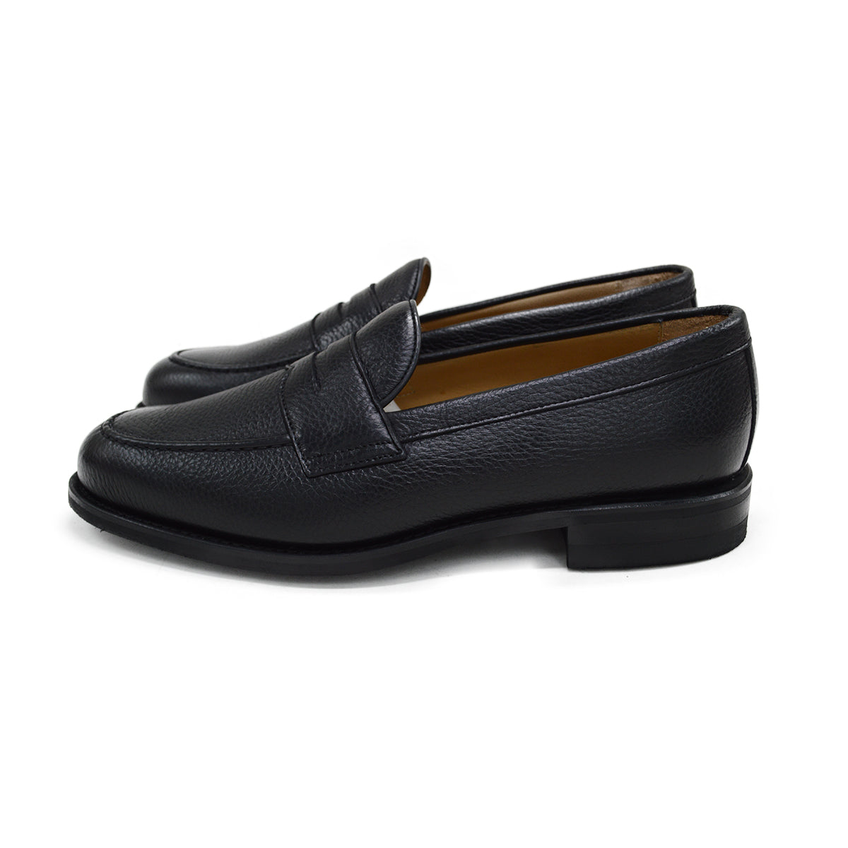 A black deerskin Penny loafer with a velvety soft texture and a classic round toe & Dainite sole, set against a white background.