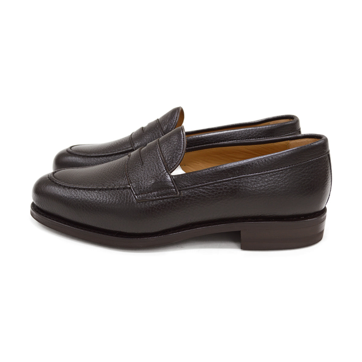 A dark brown deerskin penny loafer with a velvety soft texture and a classic round toe shape on a white background with Dainite Studded Rubber Sole.