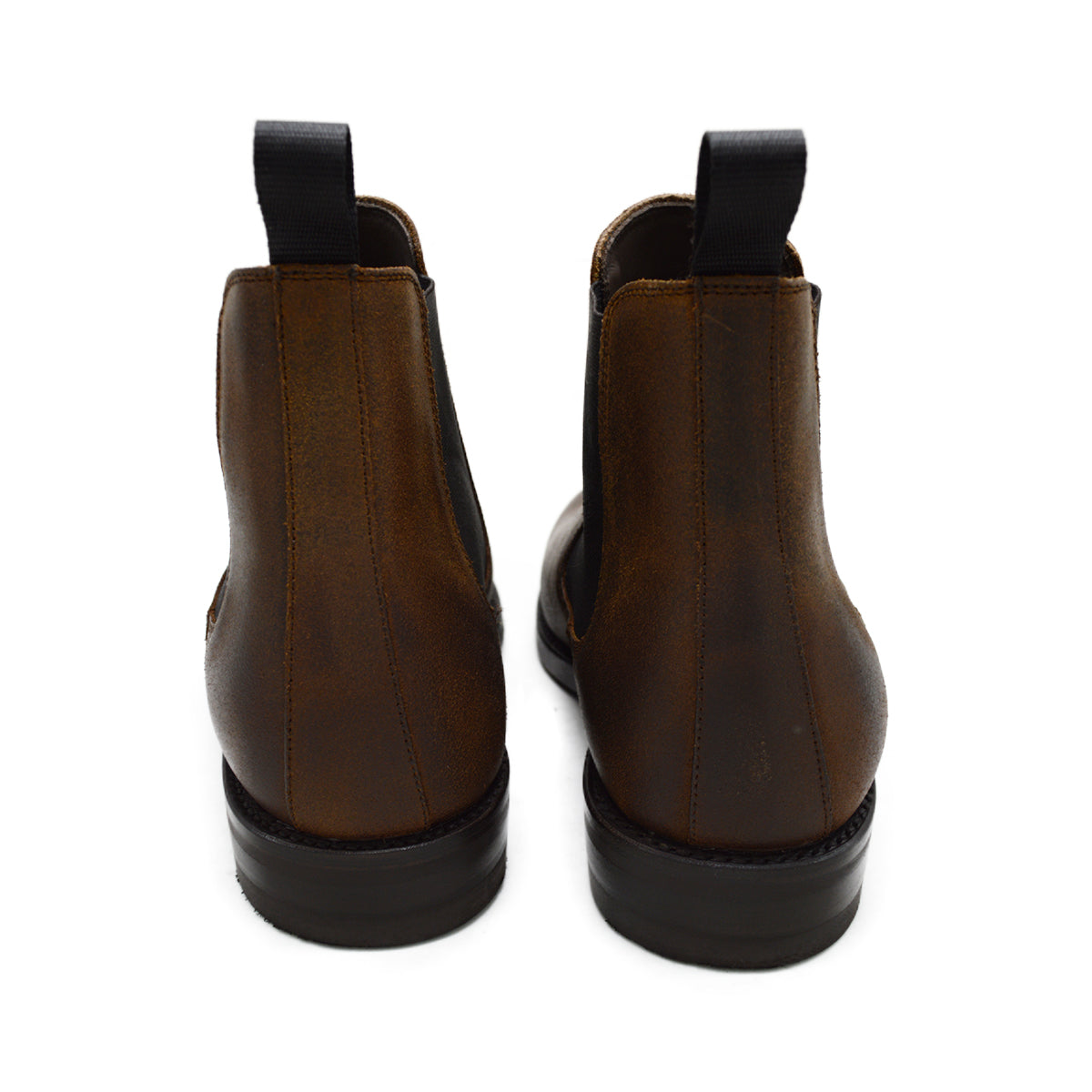 A dark brown Chelsea boot with a waxy leather finish and a contrasting black elastic side panel. The boot has a low heel and a small pull tab at the rear.