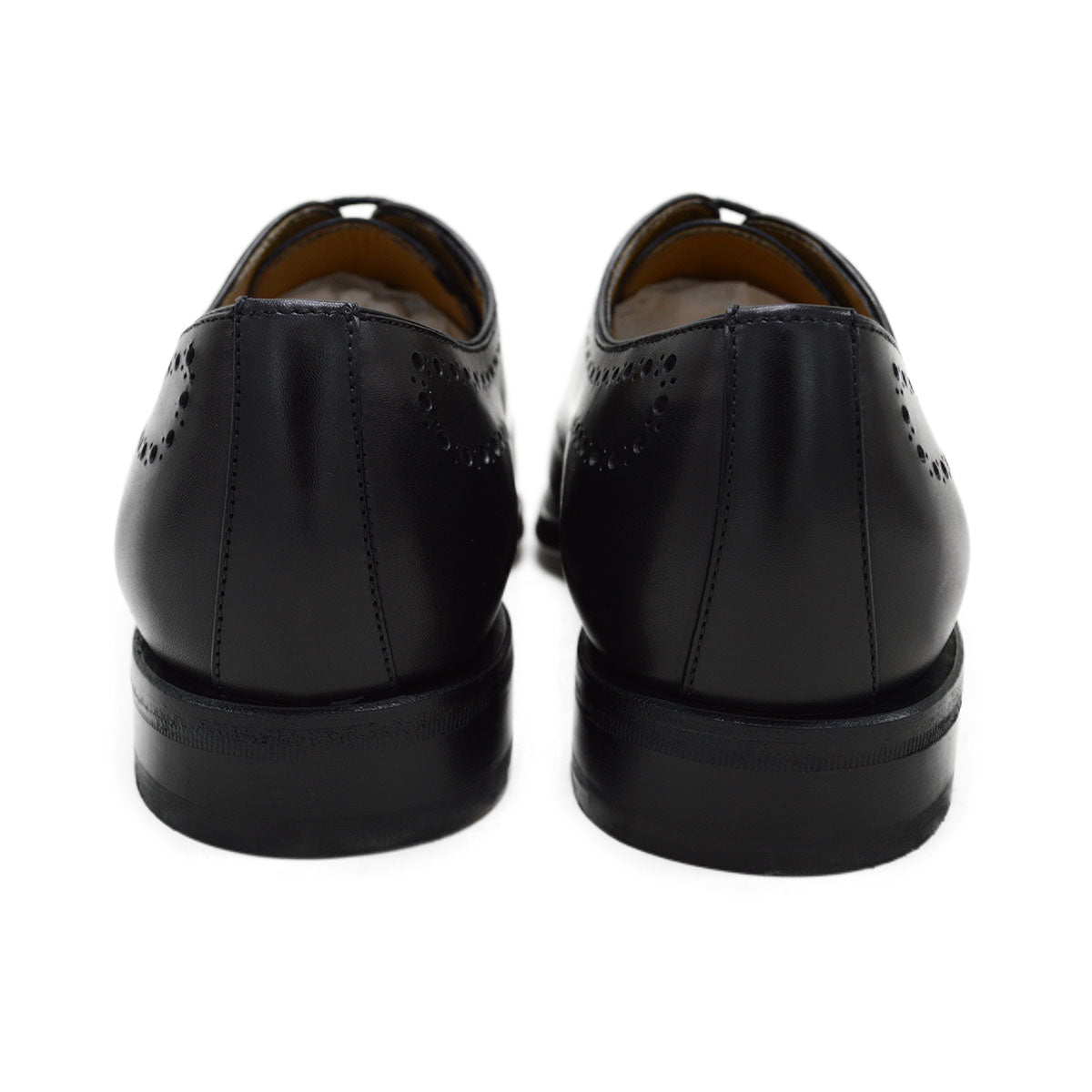 A black wholecut Oxford brogue shoe with a brogue pattern on the upper, a lace-up closure, and a goodyear welted leather sole.