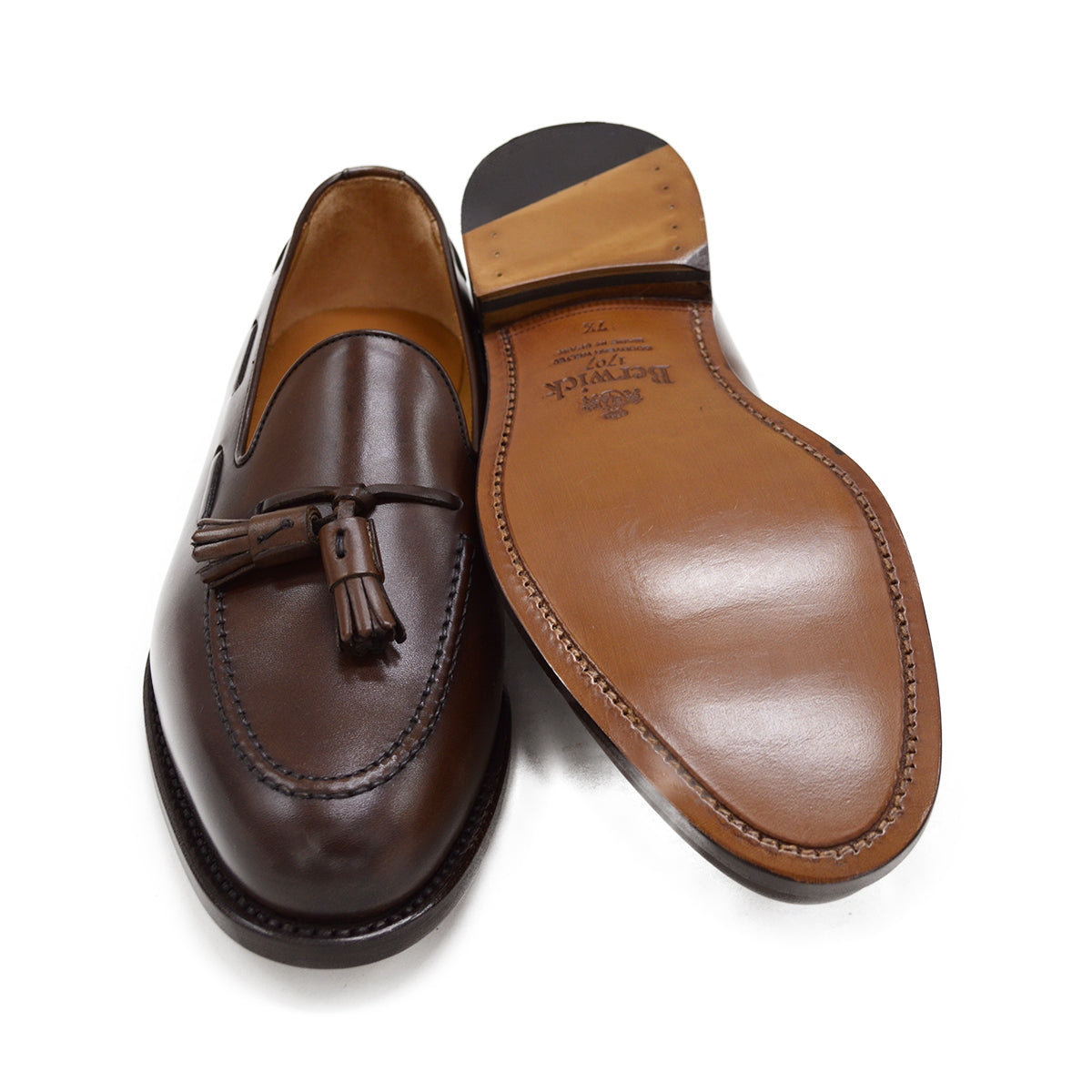 A Berwick 1707 brown tasseled loafer shoe with a closed toe and leather sole.