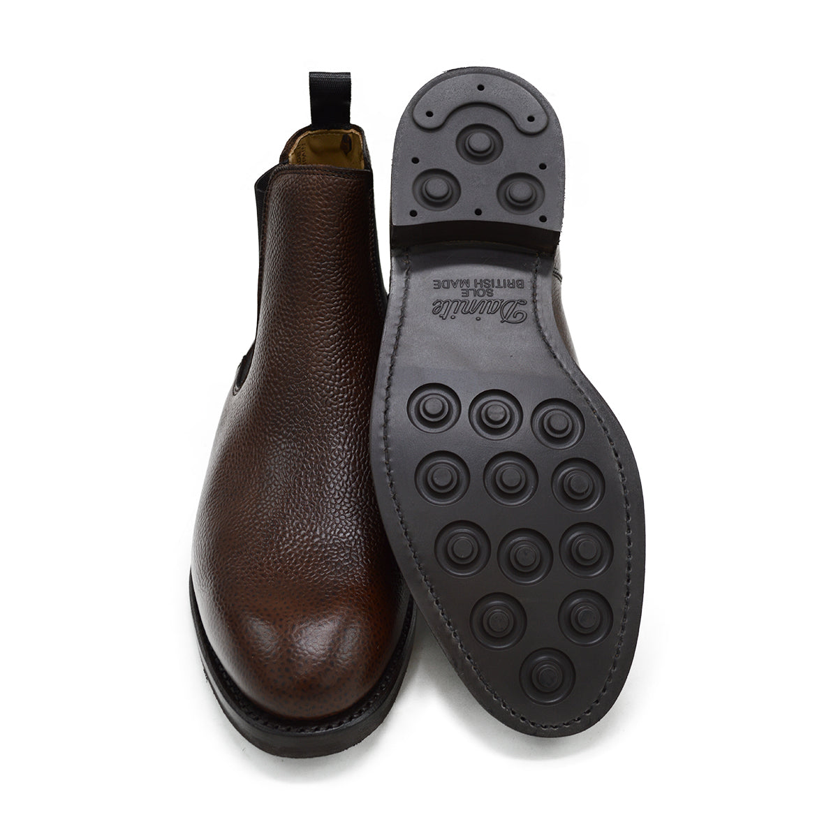 A dark brown grain leather Chelsea boot with a black elastic side panel and a round toe. The boot has a low heel and a goodyear welted dainite rubber sole.
