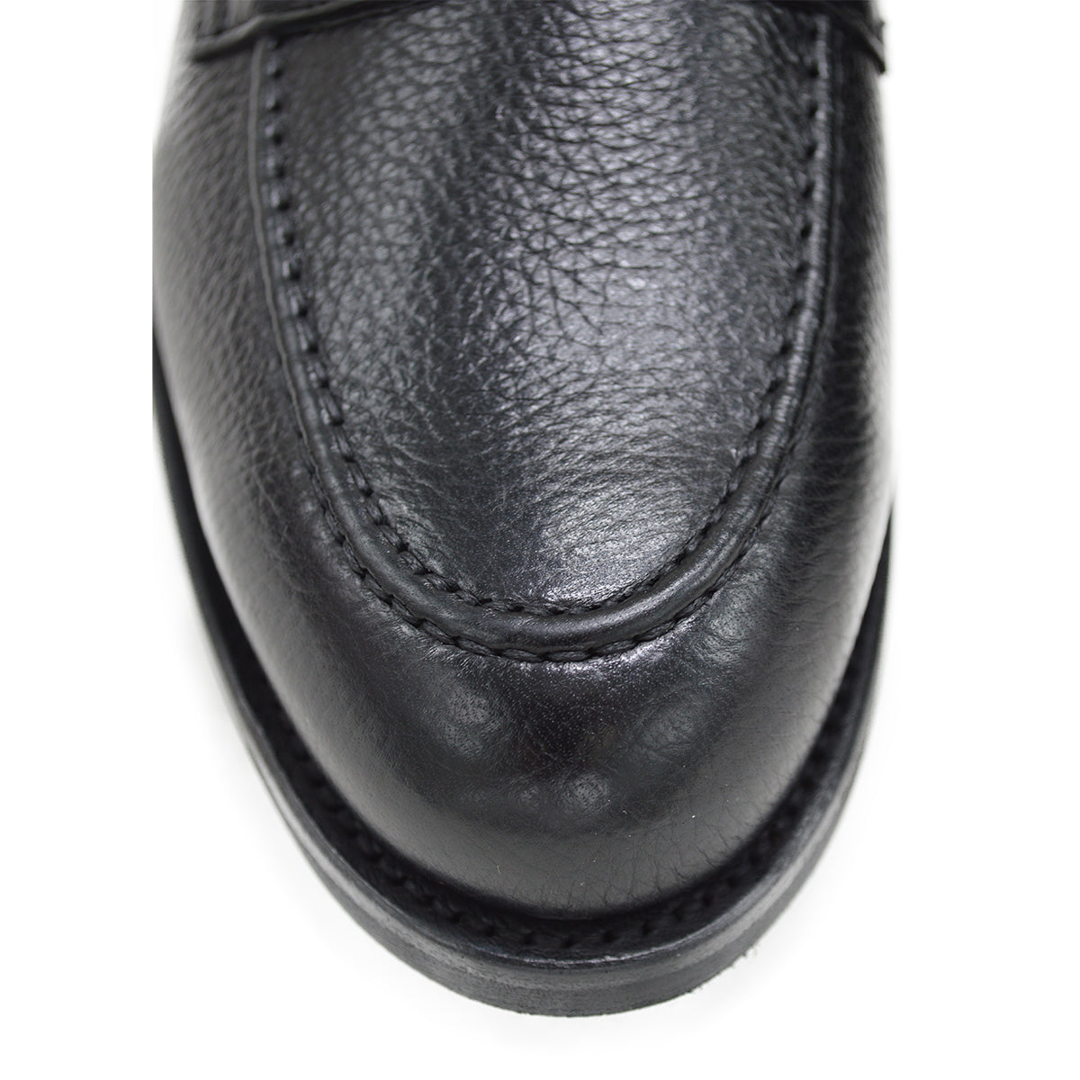 A black deerskin Penny loafer with a velvety soft texture and a classic round toe & Dainite sole, set against a white background.