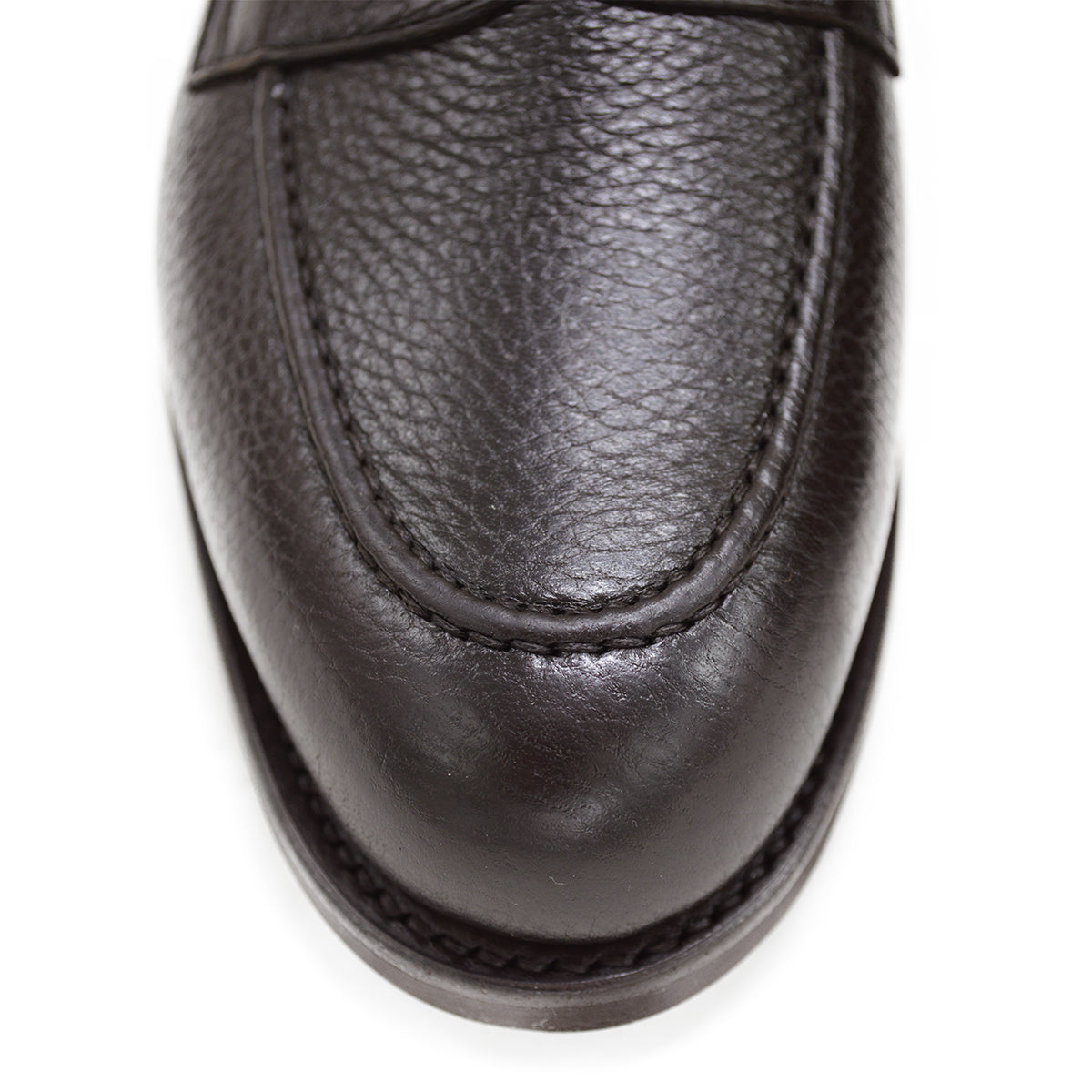 A dark brown deerskin penny loafer with a velvety soft texture and a classic round toe shape on a white background with Dainite Studded Rubber Sole.