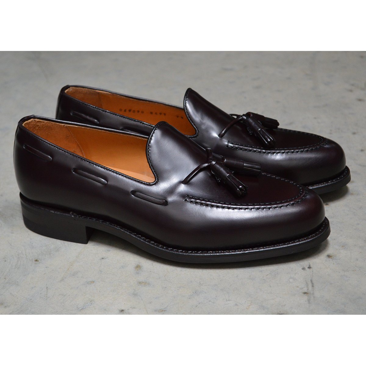 A Berwick 1707 dark brown tasselled slip-on shoe with a polished, smooth upper and a Dainite rubber sole.