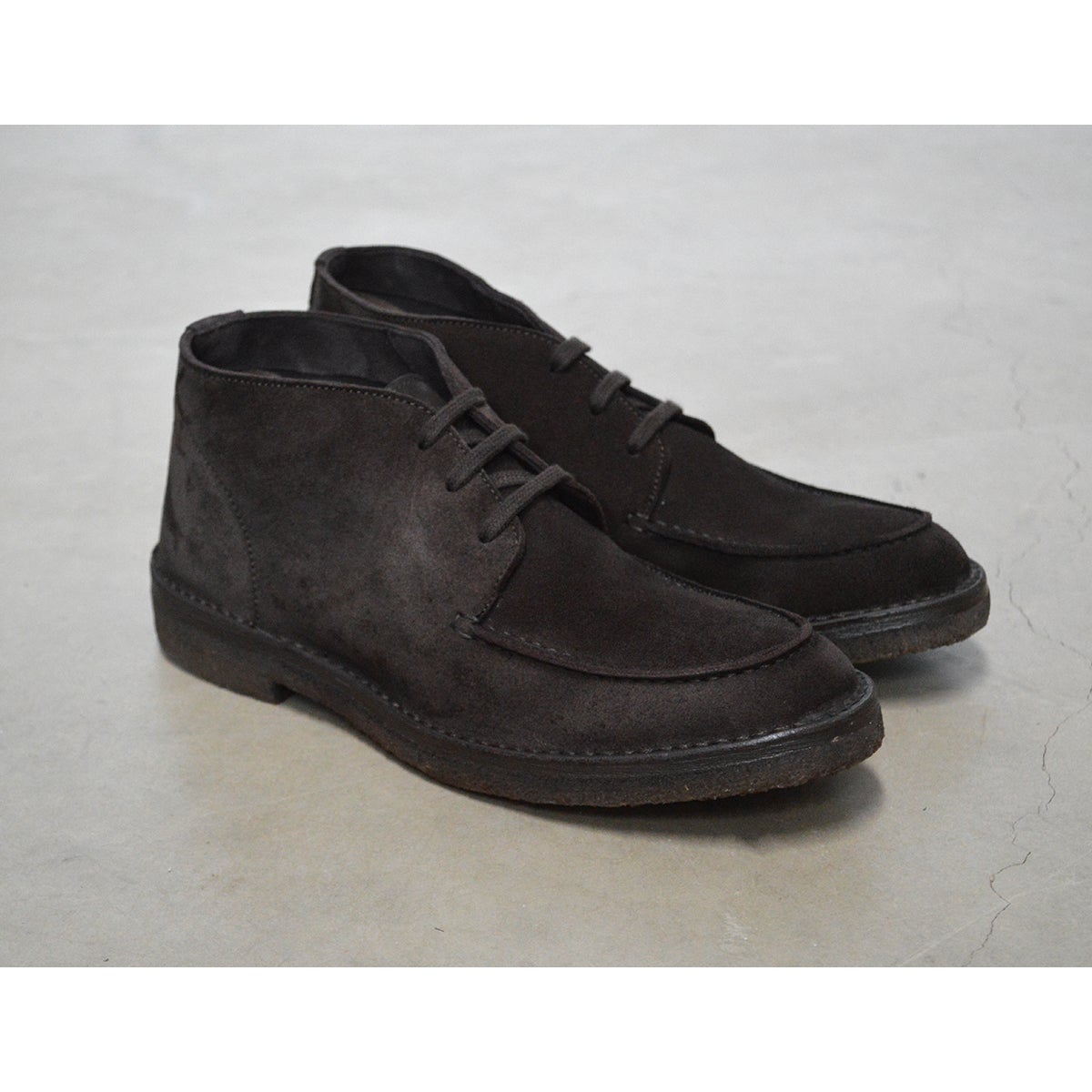 A brown Berwick 1707 apron boot with lace-up closure, handcrafted from reverse kudu suede, featuring moccasin stitching and a crepe rubber sole.