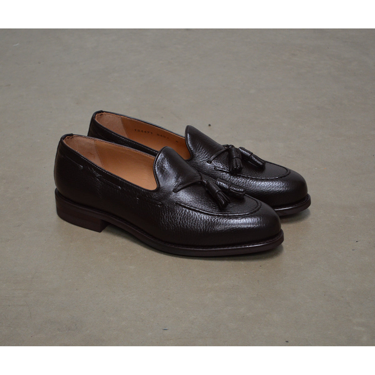 A Berwick 1707 dark brown deerskin slip-on loafer with a tassel detail on the vamp & Dainite sole
