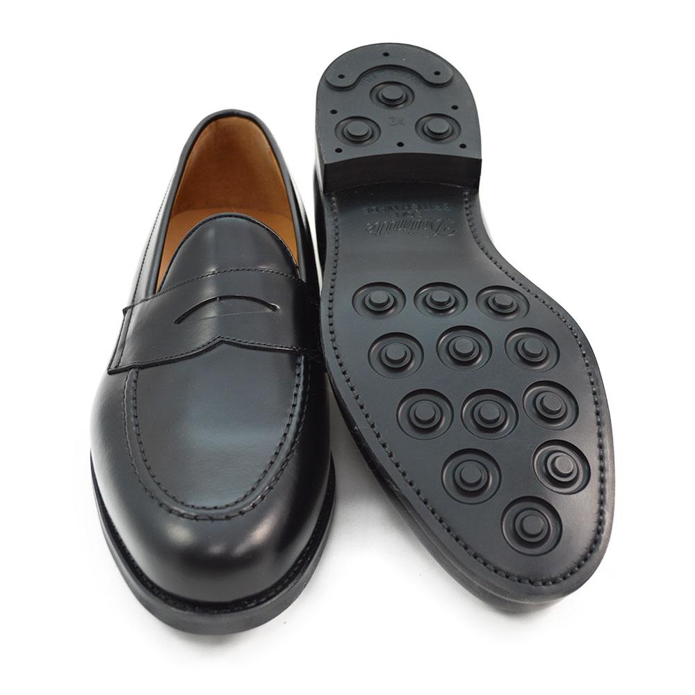 A black high-shine Berwick 1707 Penny Loafer with a round toe and Dainite rubber sole.