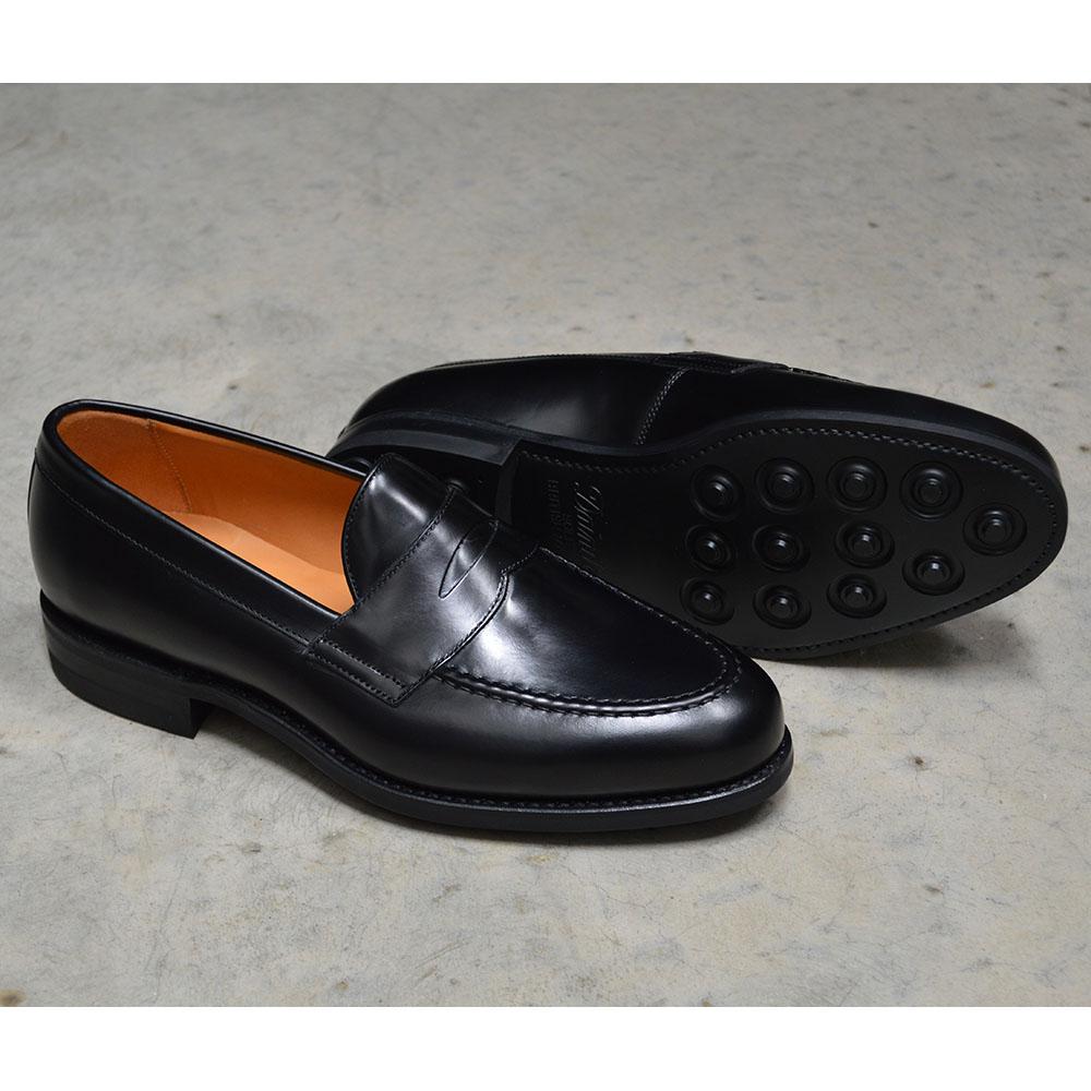 A black high-shine Berwick 1707 Penny Loafer with a round toe and Dainite rubber sole.