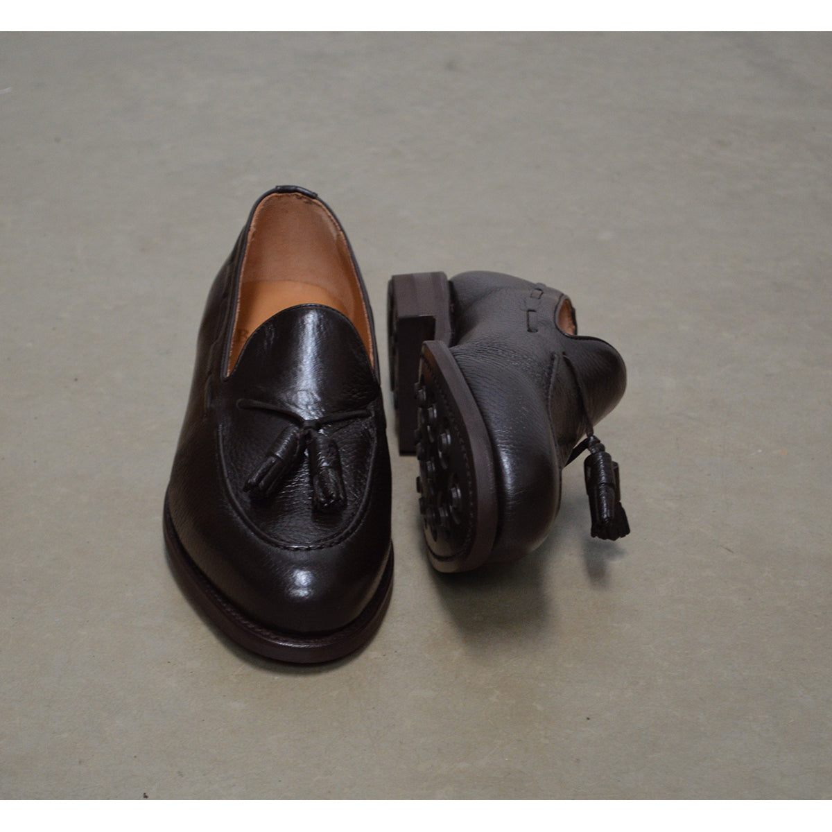 A Berwick 1707 dark brown deerskin slip-on loafer with a tassel detail on the vamp & Dainite sole