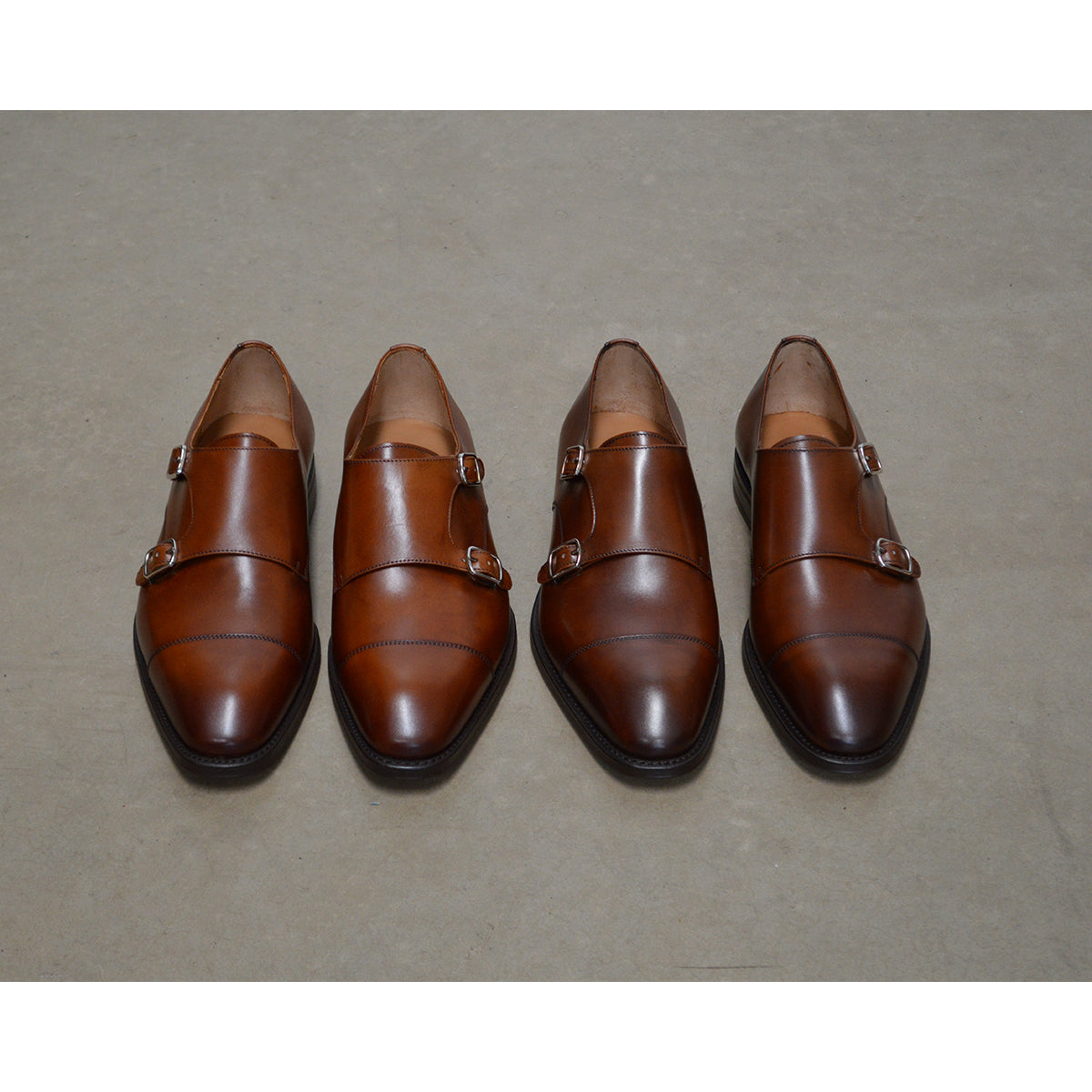 A brown Berwick 1707 double monk shoe with double buckle monk strap on polished concrete