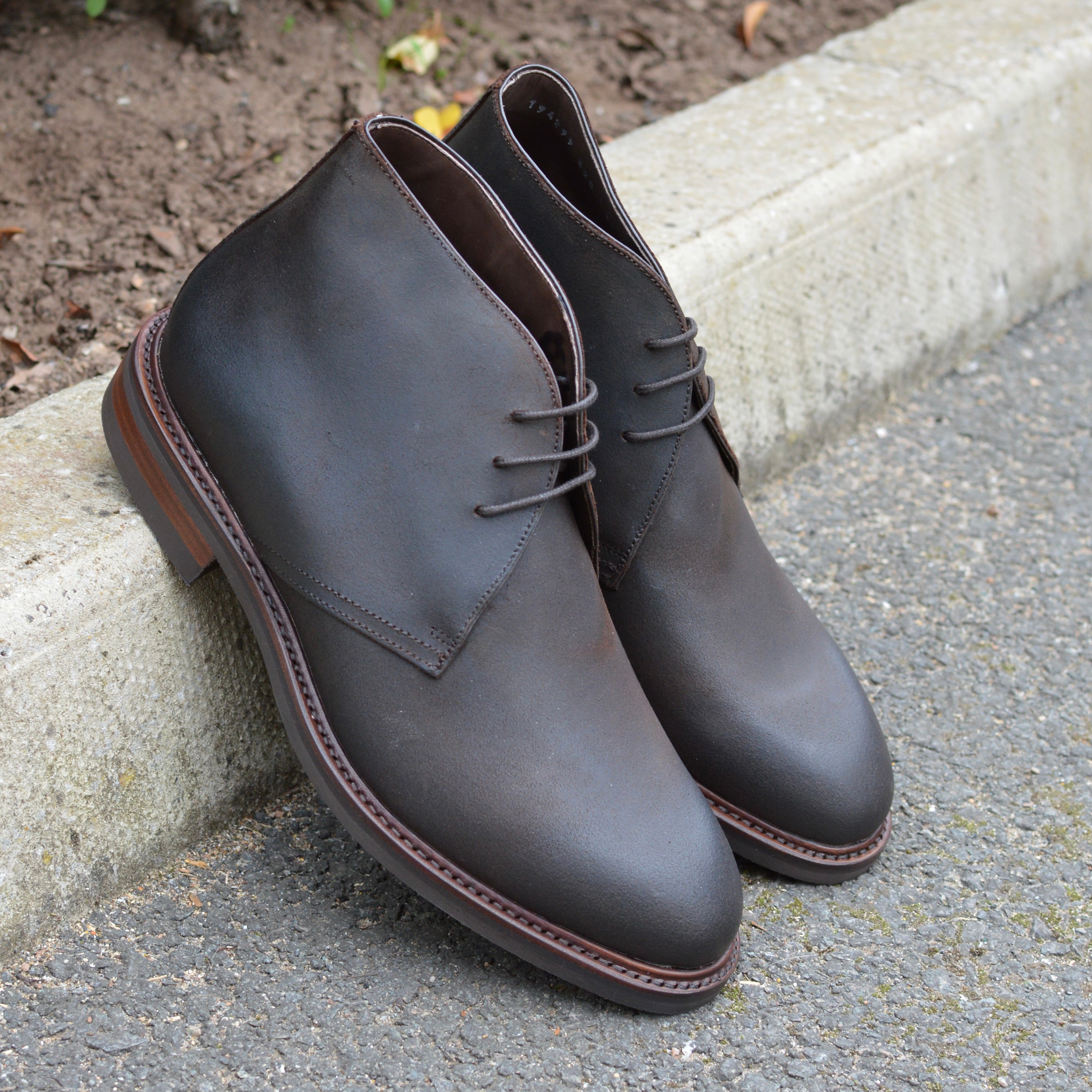 Berwick 1707 Waxy Brown leather chukka boot on a pavement edge background