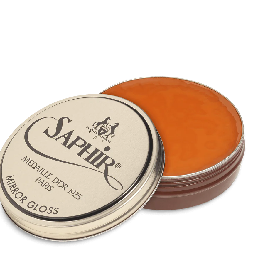 A tin of Saphir Medaille D'Or Mirror Gloss Wax Polish with the brand's logo and product name displayed on the lid.