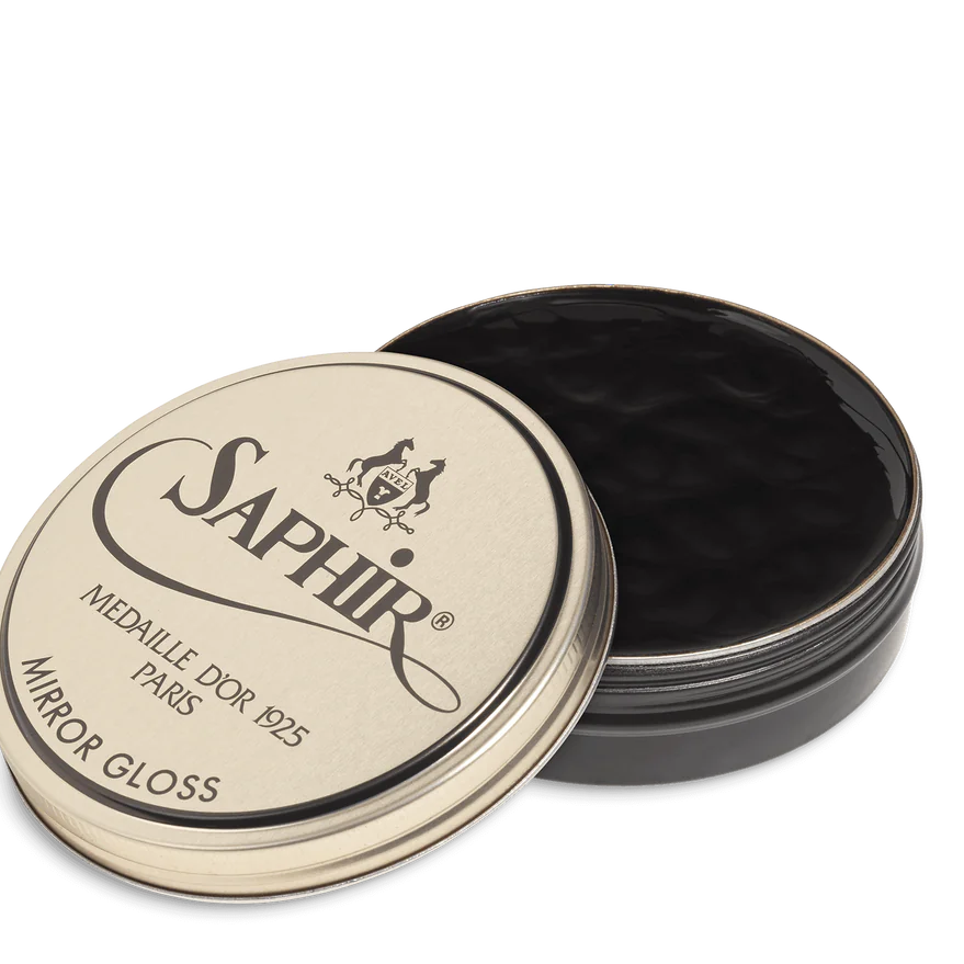 A tin of Saphir Medaille D'Or Mirror Gloss Wax Polish with the brand's logo and product name displayed on the lid.
