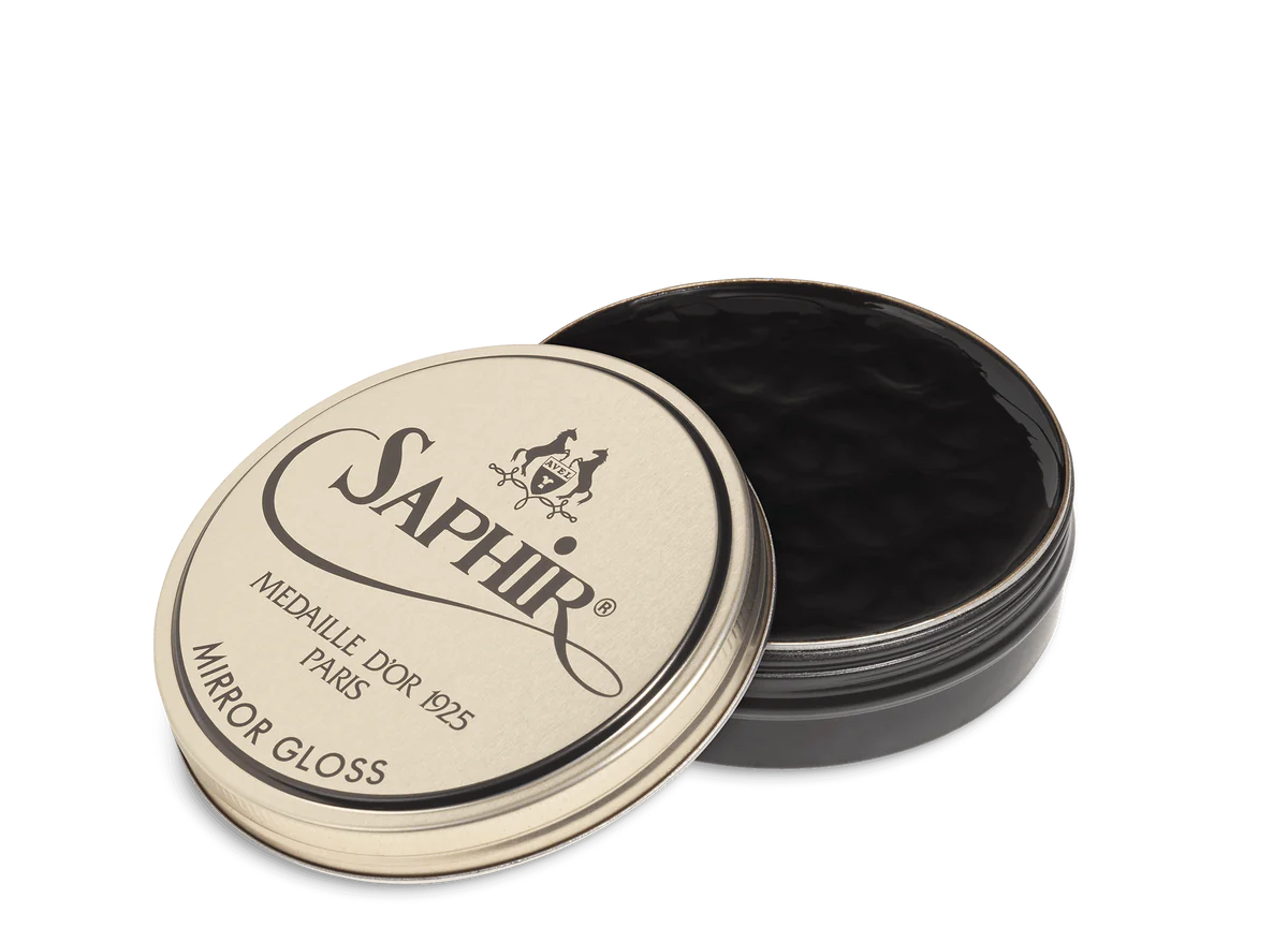 A tin of Saphir Medaille D'Or Mirror Gloss Wax Polish with the brand's logo and product name displayed on the lid.