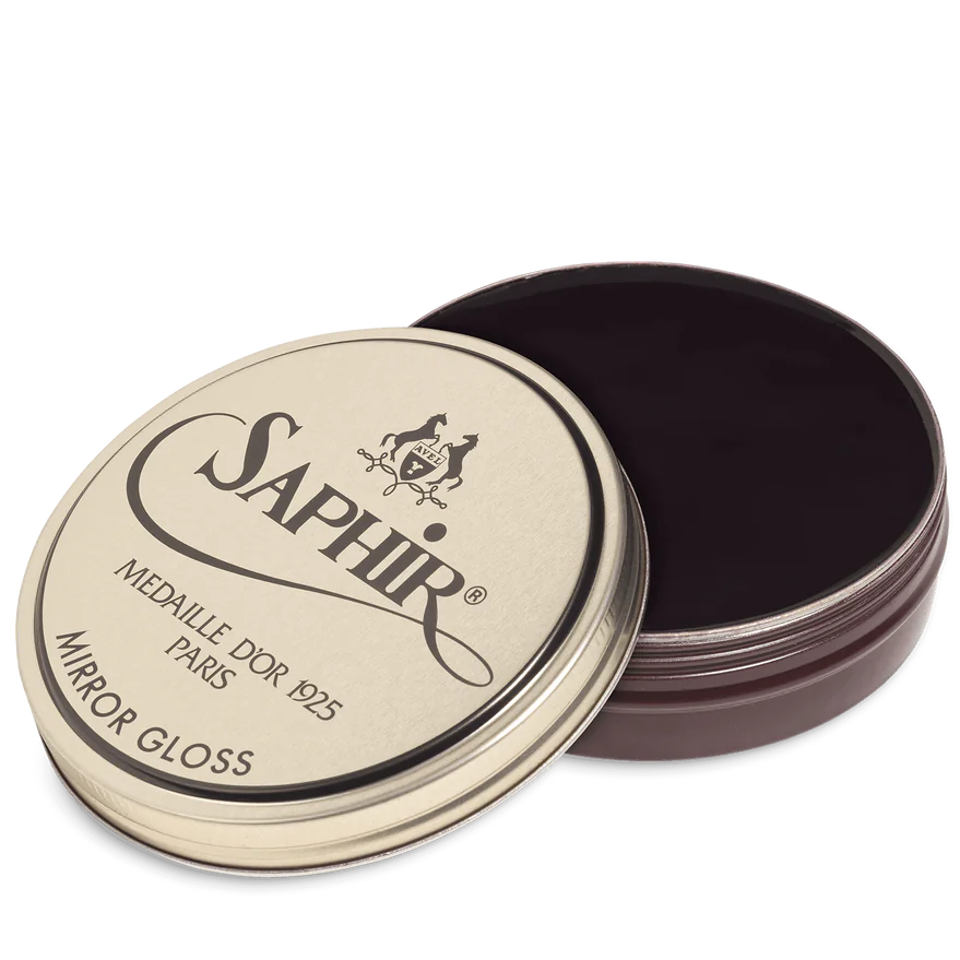 A tin of Saphir Medaille D'Or Mirror Gloss Wax Polish with the brand's logo and product name displayed on the lid.