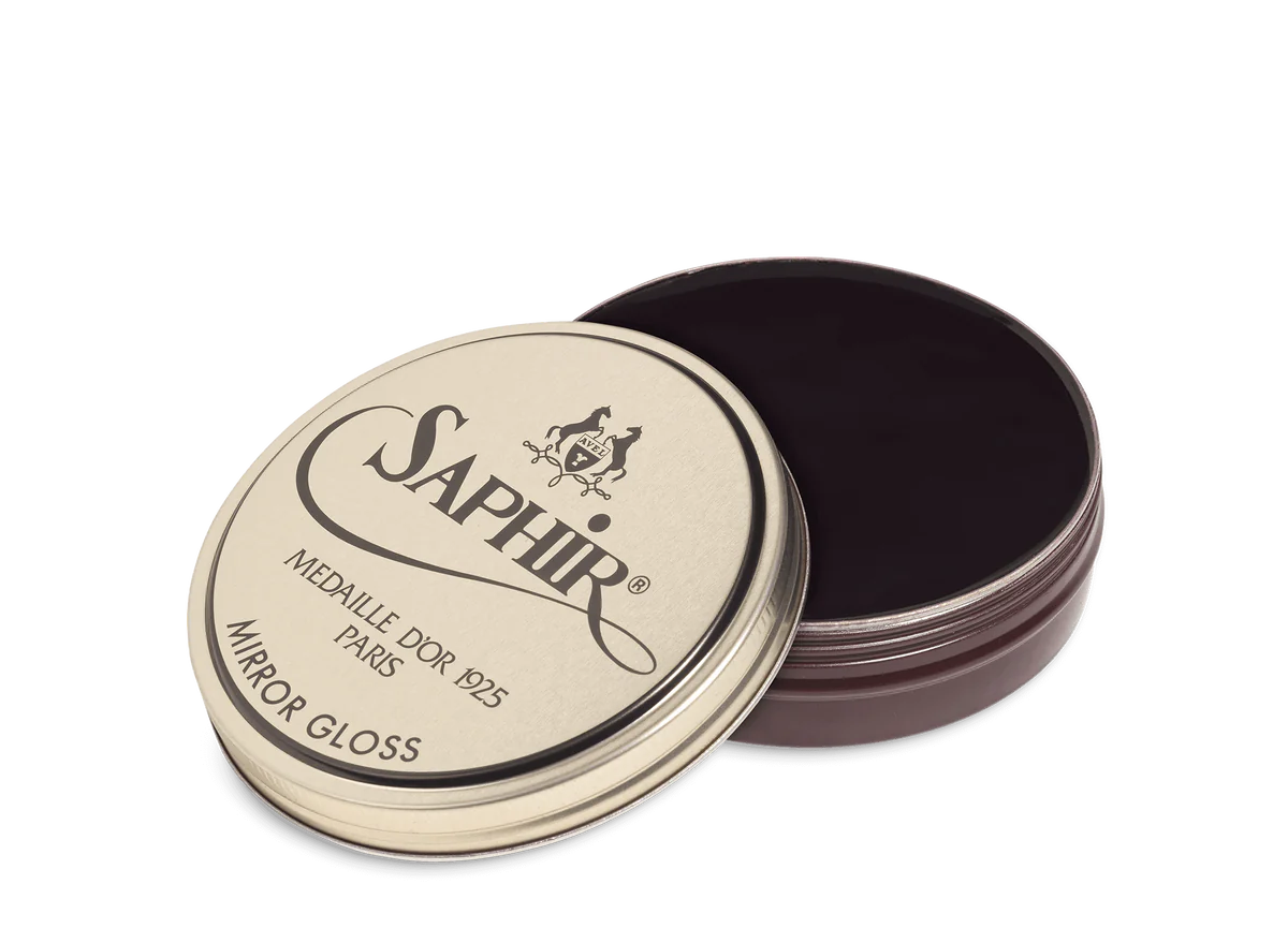 A tin of Saphir Medaille D'Or Mirror Gloss Wax Polish with the brand's logo and product name displayed on the lid.