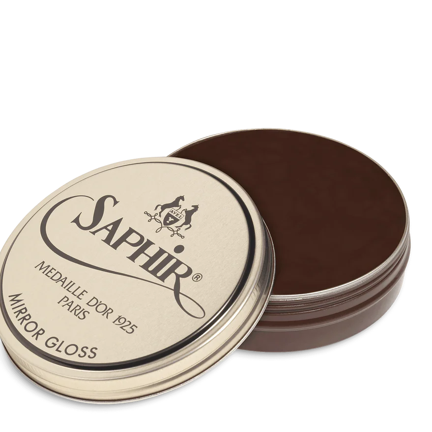 A tin of Saphir Medaille D'Or Mirror Gloss Wax Polish with the brand's logo and product name displayed on the lid.