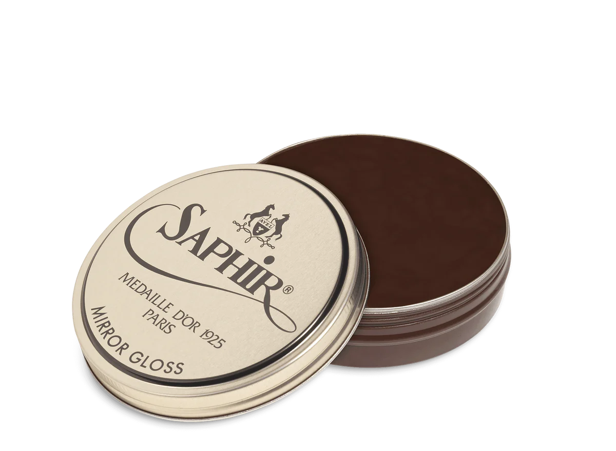 A tin of Saphir Medaille D'Or Mirror Gloss Wax Polish with the brand's logo and product name displayed on the lid.