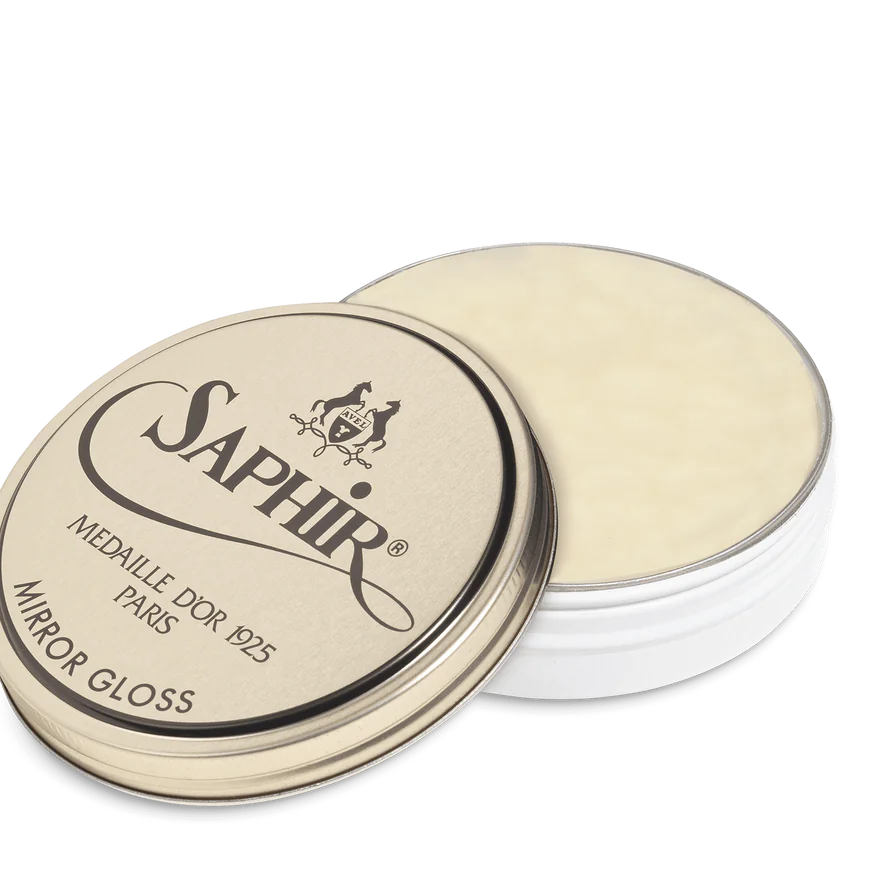 A tin of Saphir Medaille D'Or Mirror Gloss Wax Polish with the brand's logo and product name displayed on the lid.