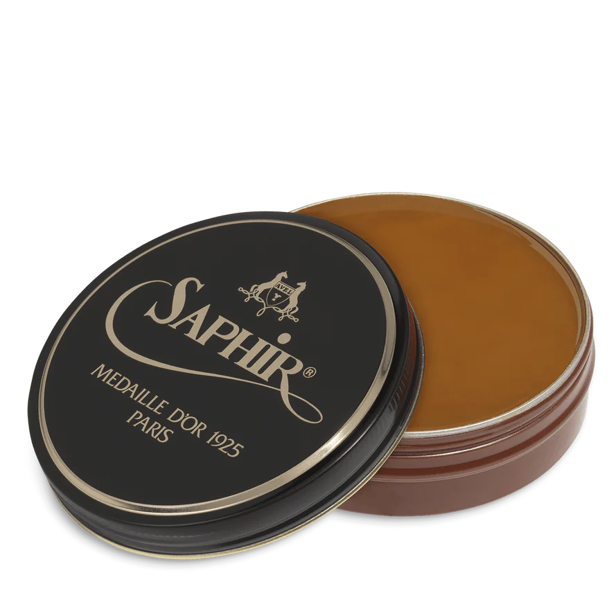 A round tin container of Saphir Medaille D'Or shoe wax polish with black lid and gold lettering.