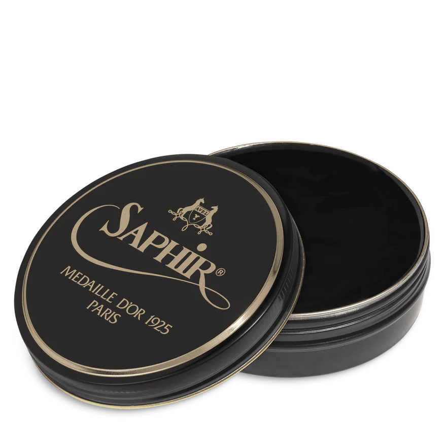 A round tin container of Saphir Medaille D'Or shoe wax polish with black lid and gold lettering.