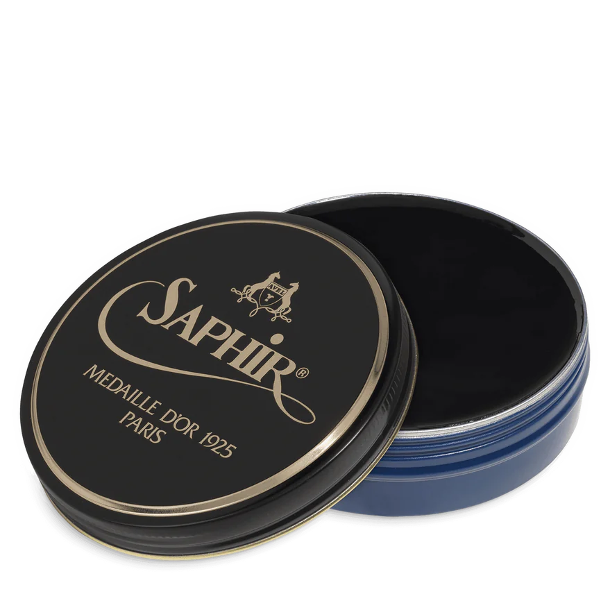 A round tin container of Saphir Medaille D'Or shoe wax polish with black lid and gold lettering.