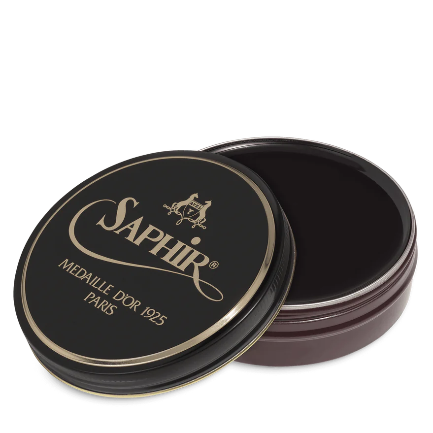 A round tin container of Saphir Medaille D'Or shoe wax polish with black lid and gold lettering.