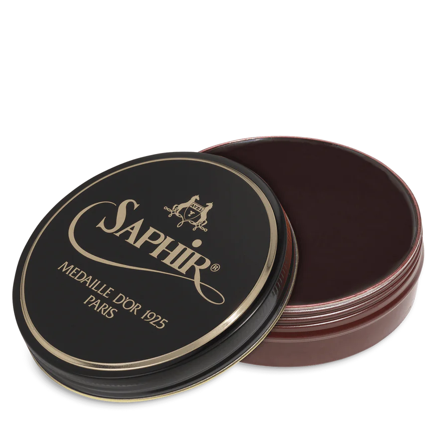A round tin container of Saphir Medaille D'Or shoe wax polish with black lid and gold lettering.