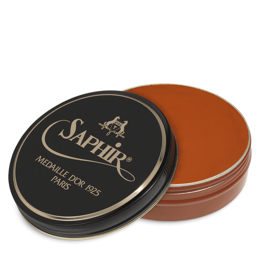A round tin container of Saphir Medaille D'Or shoe wax polish with black lid and gold lettering.