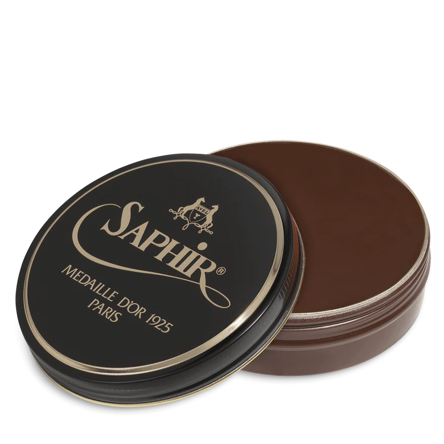A round tin container of Saphir Medaille D'Or shoe wax polish with black lid and gold lettering.