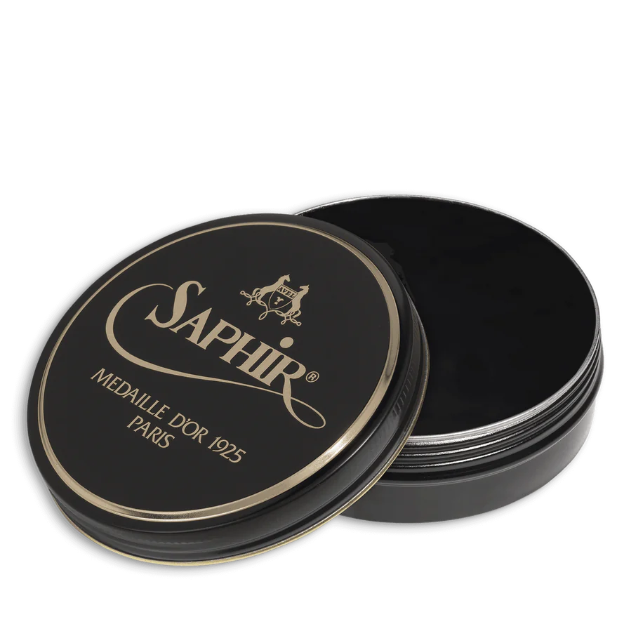 A round tin container of Saphir Medaille D'Or shoe wax polish with black lid and gold lettering.