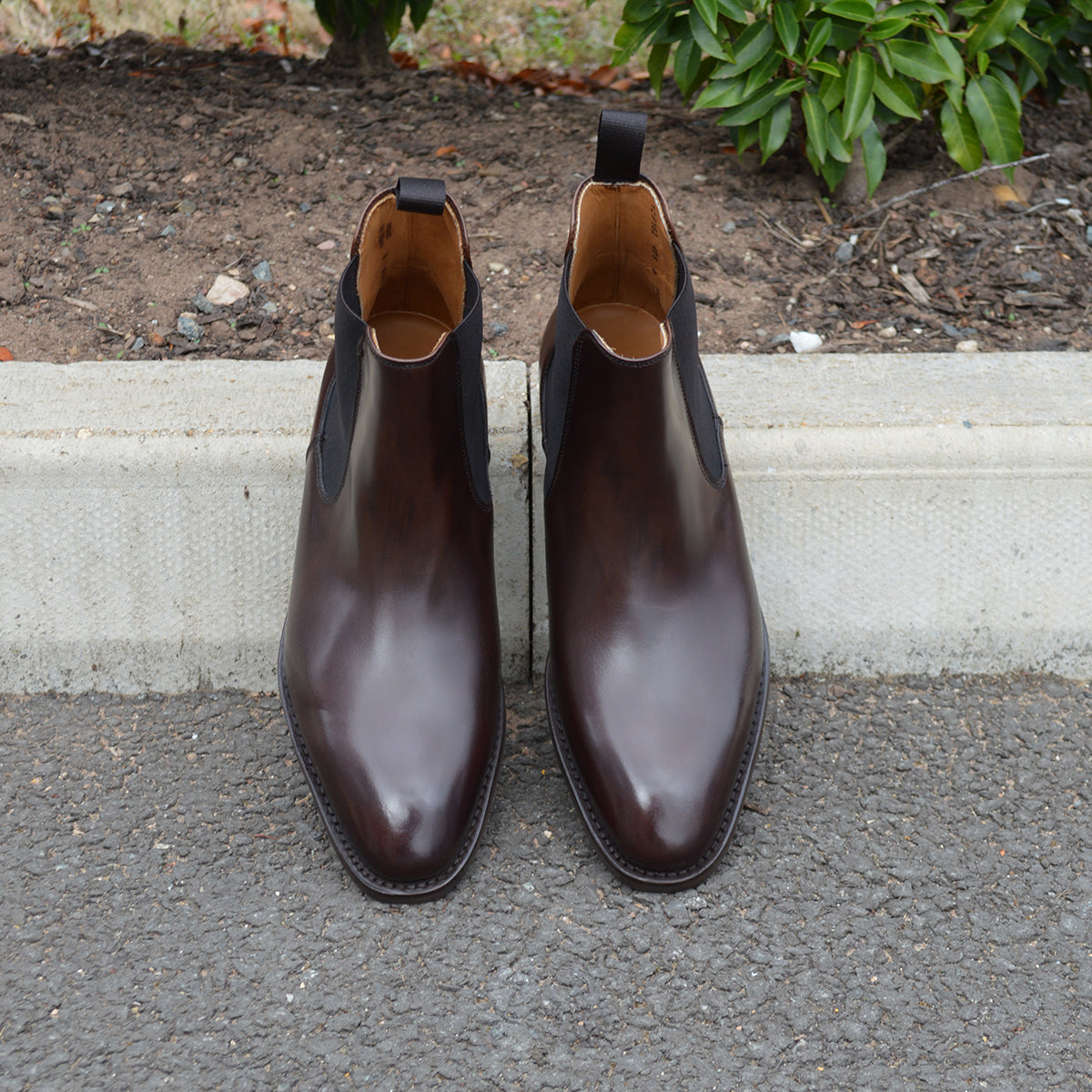 A dark brown leather Chelsea boot with a side pull tab and a low heel & Dainite soles