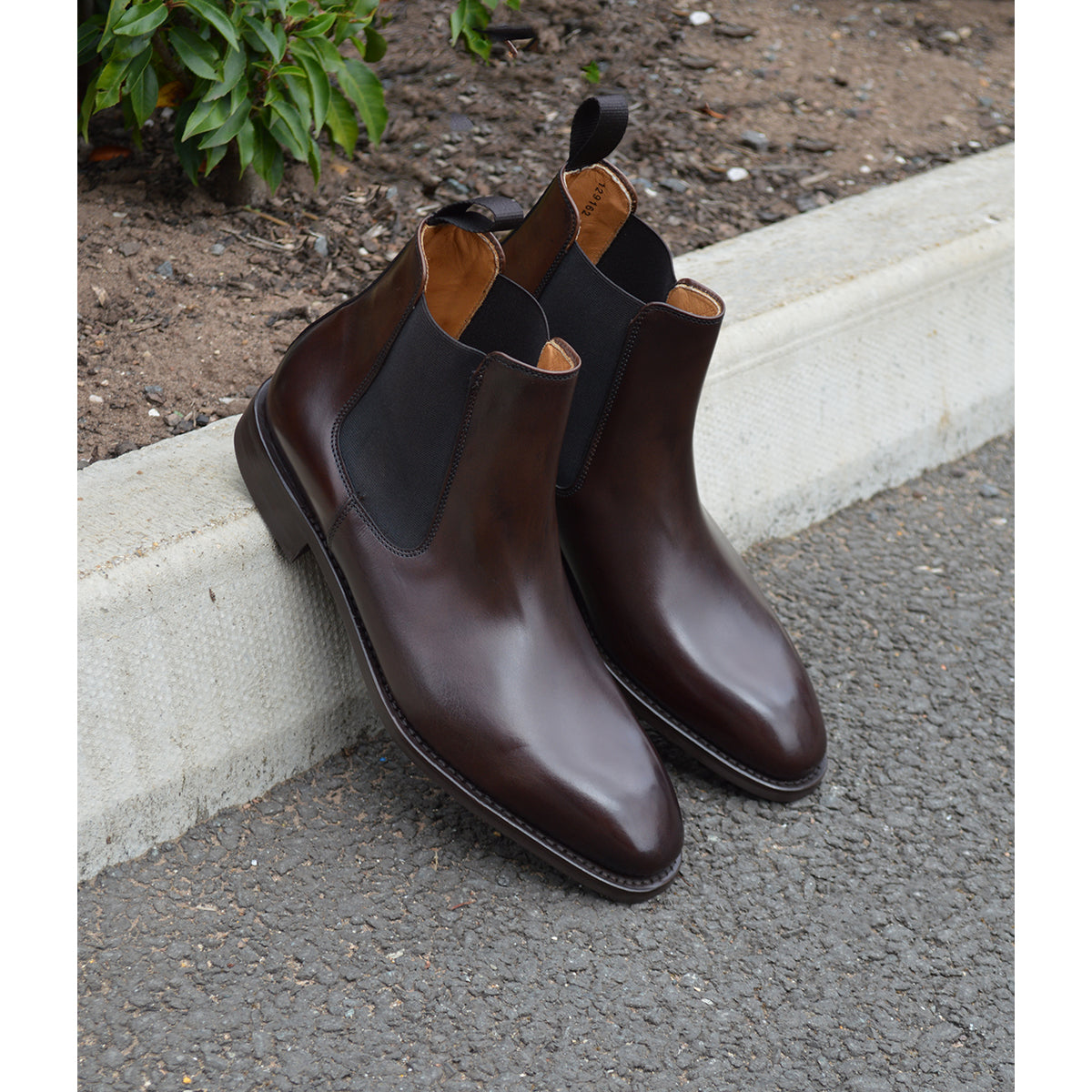 A dark brown leather Chelsea boot with a side pull tab and a low heel & Dainite soles