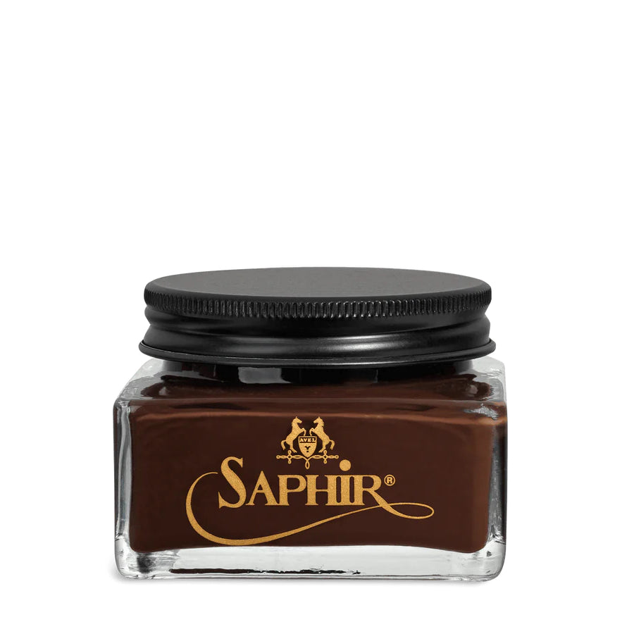 A glass jar with a black lid labeled 'SAPHIR' containing cream shoe polish.