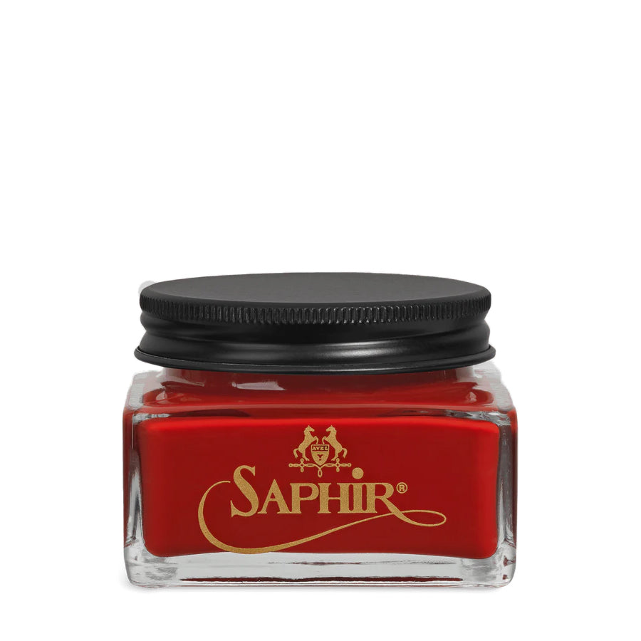 A glass jar with a black lid labeled 'SAPHIR' containing cream shoe polish.