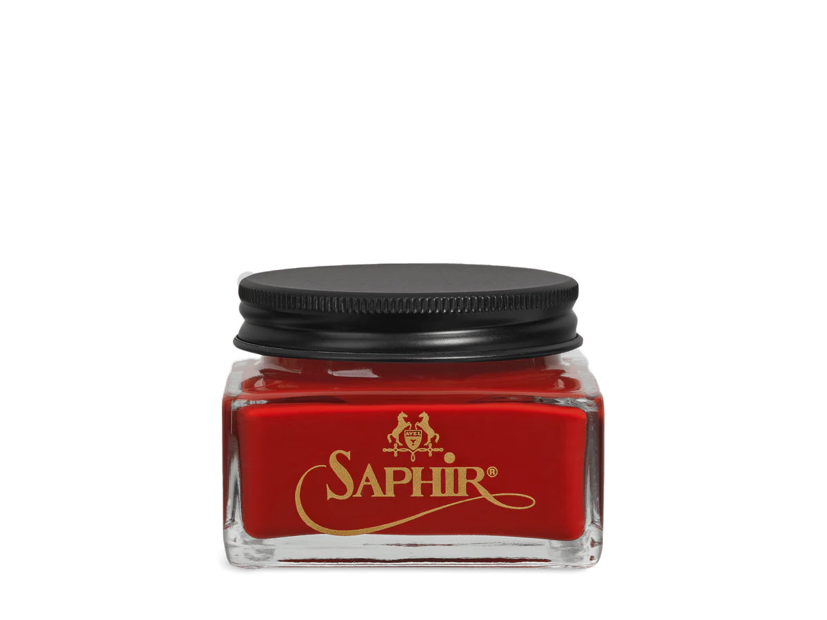 A glass jar with a black lid labeled 'SAPHIR' containing cream shoe polish.