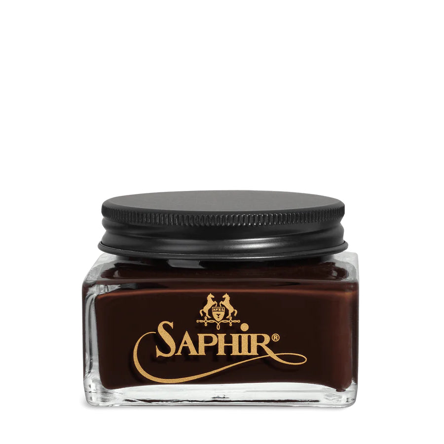 A glass jar with a black lid labeled 'SAPHIR' containing cream shoe polish.
