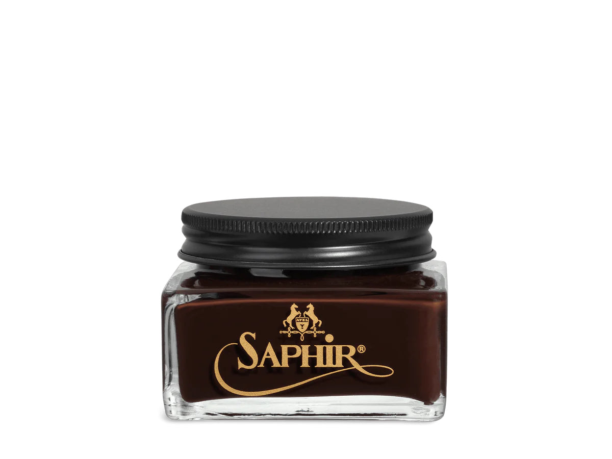A glass jar with a black lid labeled 'SAPHIR' containing cream shoe polish.