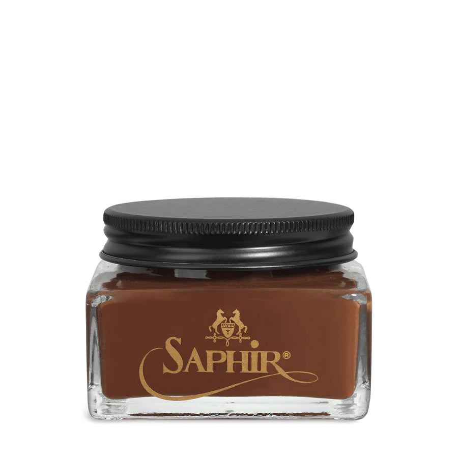 A glass jar with a black lid labeled 'SAPHIR' containing cream shoe polish.