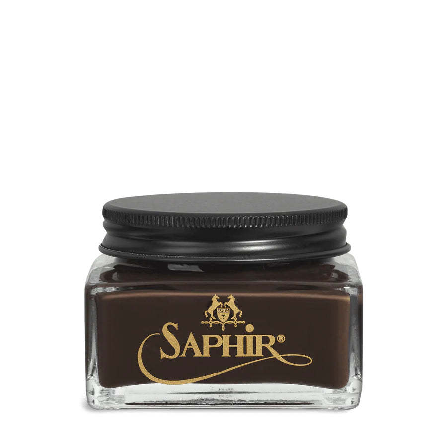 A glass jar with a black lid labeled 'SAPHIR' containing cream shoe polish.