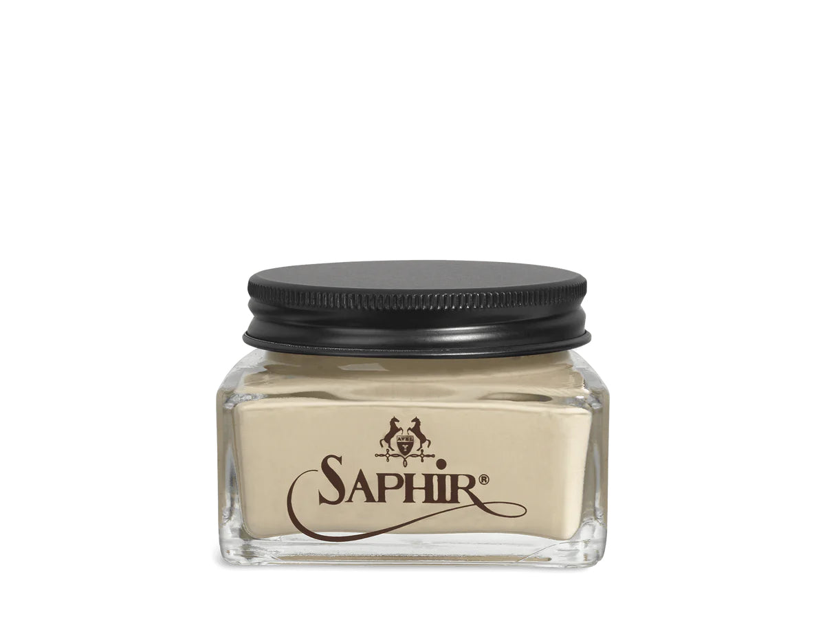 A glass jar with a black lid labeled 'SAPHIR' containing cream shoe polish.
