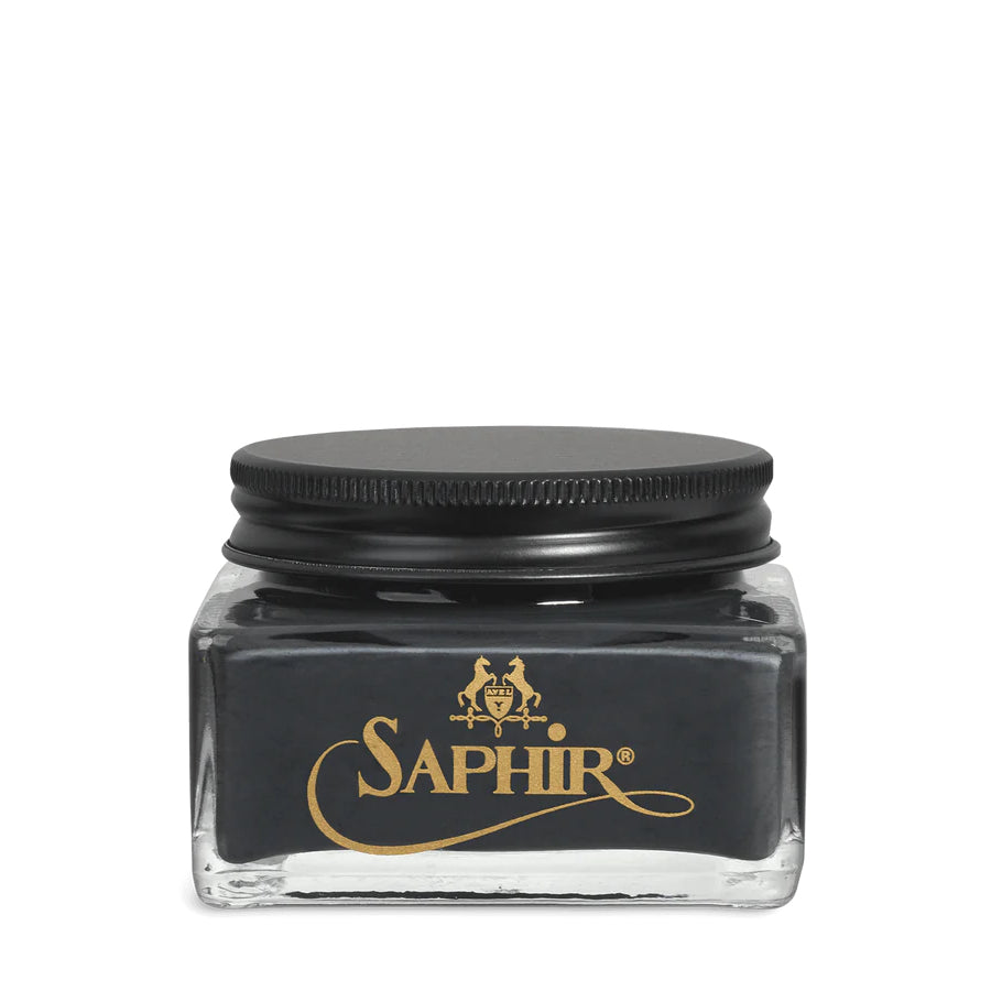 A glass jar with a black lid labeled 'SAPHIR' containing cream shoe polish.