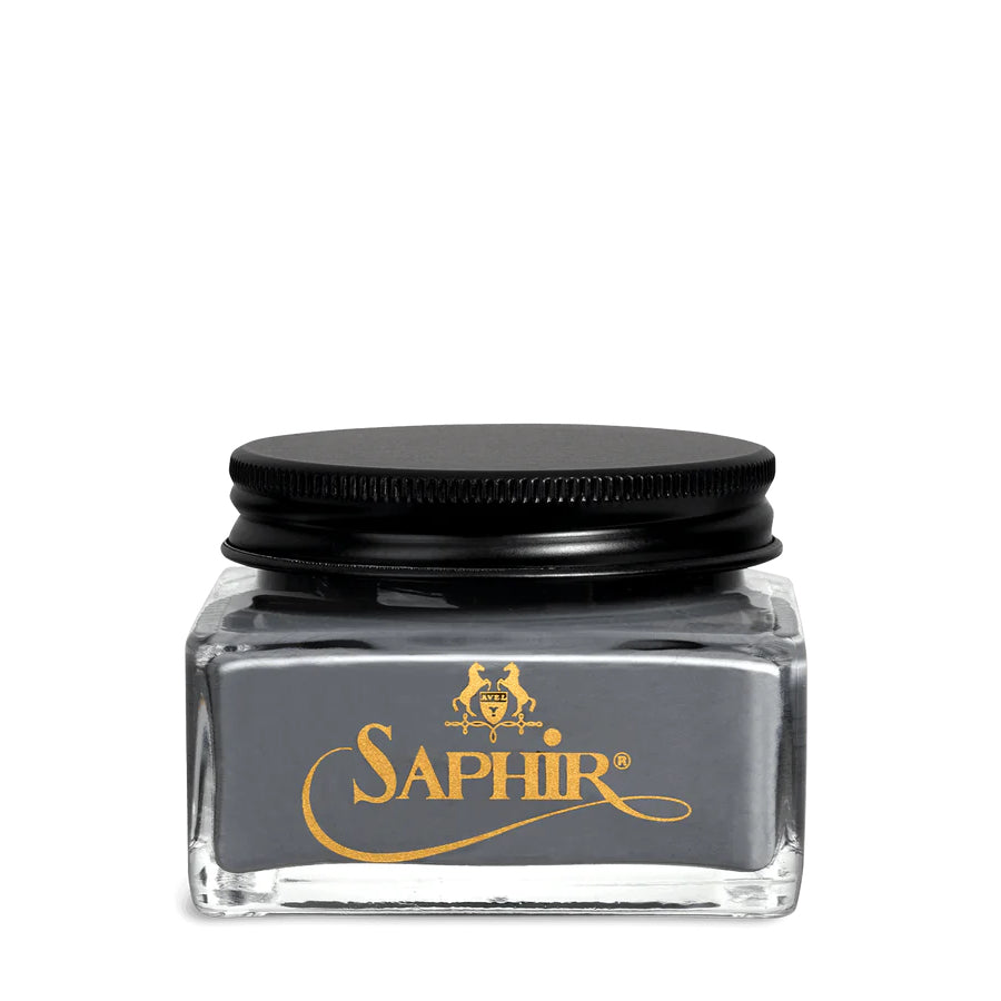 A glass jar with a black lid labeled 'SAPHIR' containing cream shoe polish.