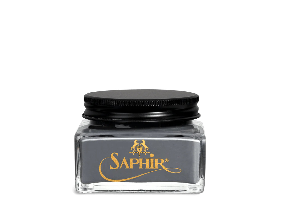 A glass jar with a black lid labeled 'SAPHIR' containing cream shoe polish.