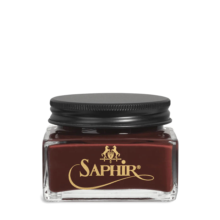 A glass jar with a black lid labeled 'SAPHIR' containing cream shoe polish.